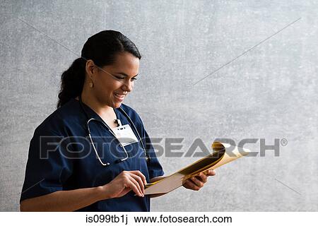 Hospital nurse looking at medical chart View Large Photo Image Stock Image - Hospital nurse looking at medical chart. Fotosearch