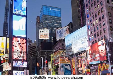 Stock Image - Illuminated billboards in Times Square. Fotosearch
