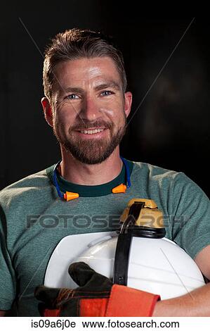 Stock Image - Industrial worker carrying hard hat. Fotosearch