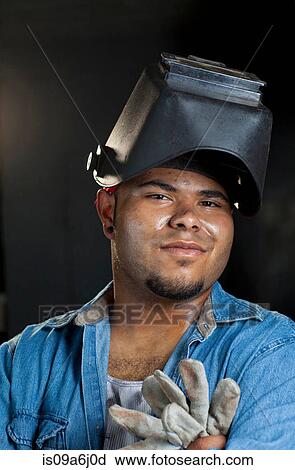 Stock Image - Industrial worker in welding helmet. Fotosearch