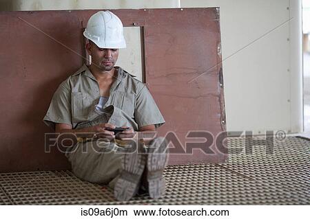 Picture - Industrial worker using cell phone. Fotosearch