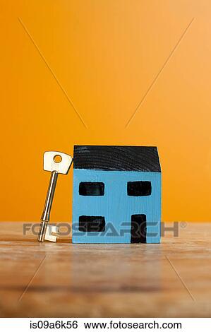 Key leaning on model house View Large Photo Image Stock Photograph - Key leaning on model house. Fotosearch