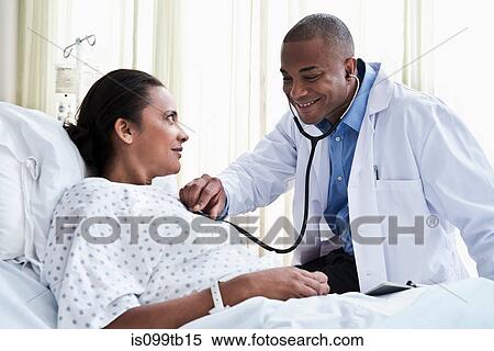 Male doctor checking female patient with stethoscope View Large Photo Image Stock Photography - Male doctor checking female patient with stethoscope. Fotosearch