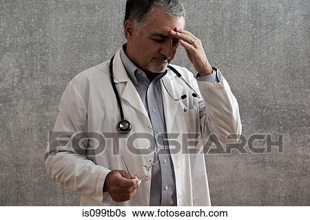 Male doctor looking stressed View Large Photo Image Stock Photograph - Male doctor looking stressed. Fotosearch