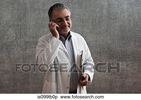 Male doctor on cellphone View Large Photo Image Stock Photography - Male doctor on cellphone. Fotosearch