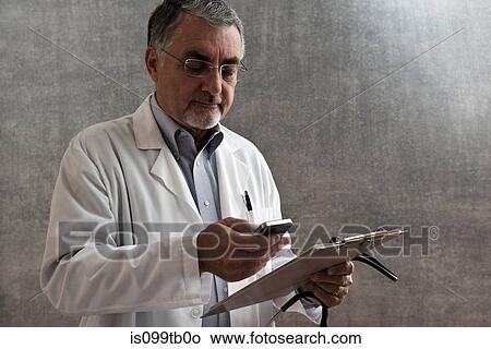 Male doctor with cellphone and clipboard View Large Photo Image Picture - Male doctor with cellphone and clipboard. Fotosearch