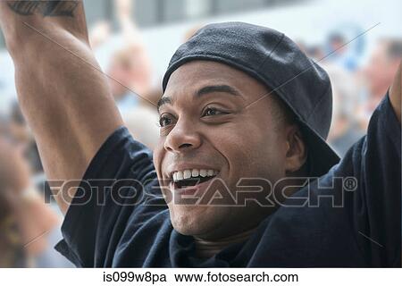 Man at sports game with arms raised View Large Photo Image Stock Image - Man at sports game with arms raised. Fotosearch
