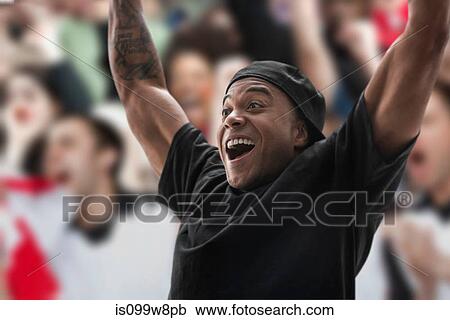Man at sports game with arms raised View Large Photo Image Stock Image - Man at sports game with arms raised. Fotosearch