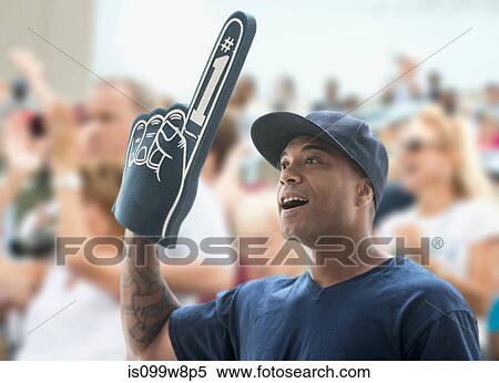 Man at sports game with foam hand View Large Photo Image Stock Photography - Man at sports game with foam hand. Fotosearch