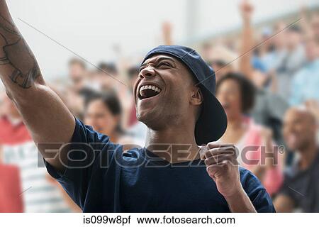 Stock Image - Man cheering at sports game. Fotosearch