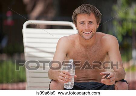 Man drinking water by swimming pool View Large Photo Image Stock Photo - Man drinking water by swimming pool. Fotosearch