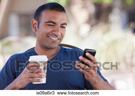 Stock Image - Man having cup of coffee outdoors. Fotosearch