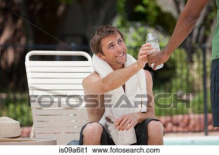 Stock Image - Man having water in swimming pool. Fotosearch