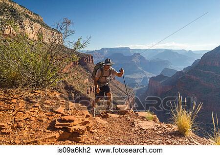 Stock Image - Man hiking trail in Grand Canyon. Fotosearch