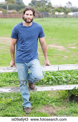 Man leaning on wooden fence View Large Photo Image Stock Image - Man leaning on wooden fence. Fotosearch