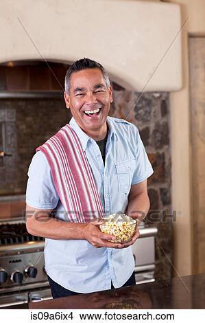 Picture - Man making popcorn in kitchen. Fotosearch