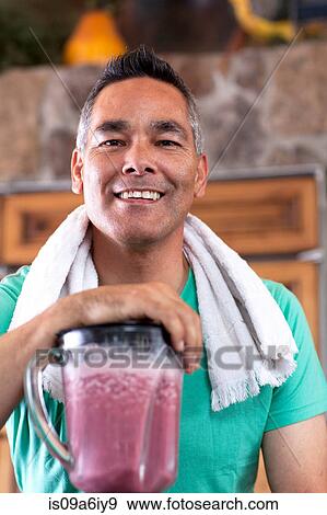 Stock Photo - Man making smoothie in kitchen. Fotosearch