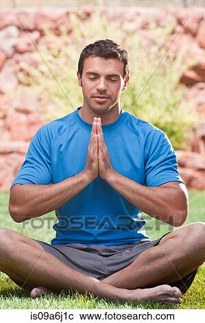 Stock Image - Man meditating outdoors. Fotosearch