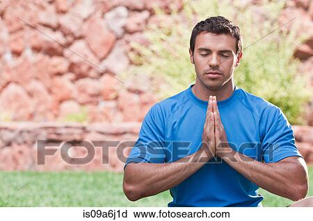 Stock Image - Man meditating outdoors. Fotosearch