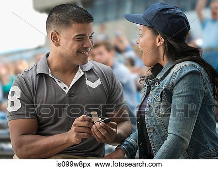 Man proposing to girlfriend at sports game View Large Photo Image Stock Photo - Man proposing to girlfriend at sports game. Fotosearch