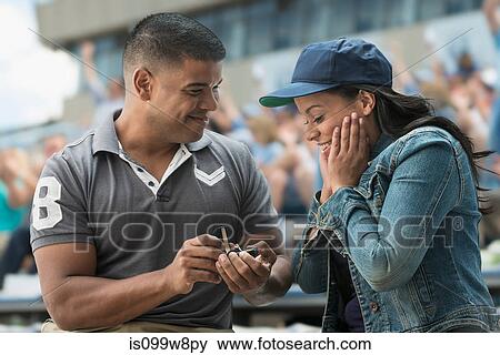 Man proposing to girlfriend at sports game View Large Photo Image Stock Photo - Man proposing to girlfriend at sports game. Fotosearch