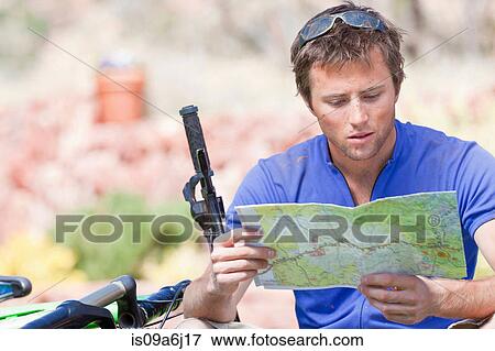 Man reading map on mountain bike View Large Photo Image Stock Photo - Man reading map on mountain bike. Fotosearch