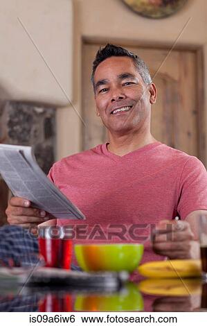 Stock Photograph - Man reading newspaper at breakfast. Fotosearch