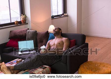 Man relaxing on sofa View Large Photo Image Stock Image - Man relaxing on sofa. Fotosearch