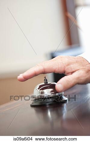 Picture - Man ringing bell in hotel lobby. Fotosearch