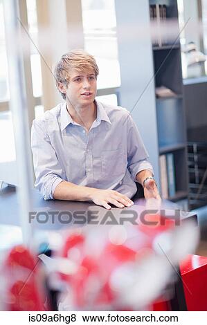 Stock Photo - Man sitting at desk in office. Fotosearch
