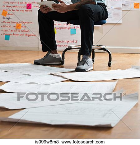Man sitting on stool with digital tablet View Large Photo Image Stock Photo - Man sitting on stool with digital tablet. Fotosearch