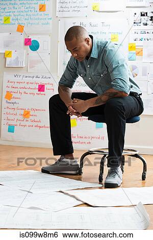 Man sitting on stool with digital tablet View Large Photo Image Stock Photograph - Man sitting on stool with digital tablet. Fotosearch
