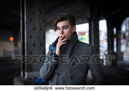 Stock Photograph - Man smoking cigarette outdoors. Fotosearch