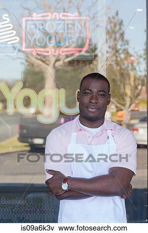 Stock Photo - Man standing by frozen yogurt store. Fotosearch