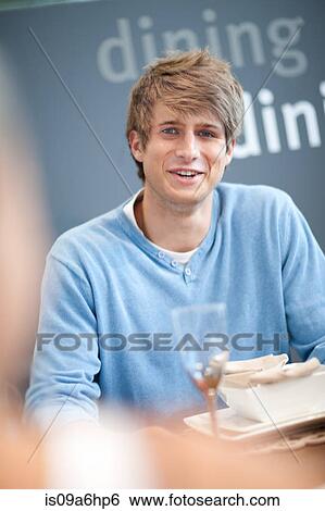Stock Photograph - Man talking at dinner table. Fotosearch