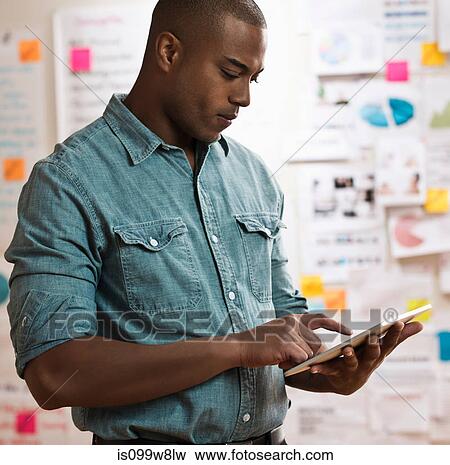 Stock Photo - Man using digital tablet. Fotosearch