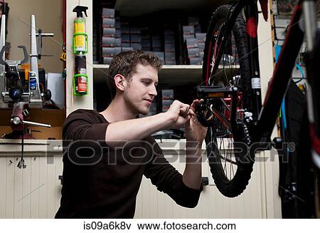 Stock Photo - Mechanic working in bicycle repair shop. Fotosearch