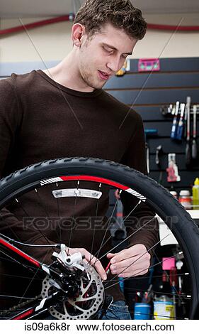 Stock Photography - Mechanic working in bicycle repair shop. Fotosearch