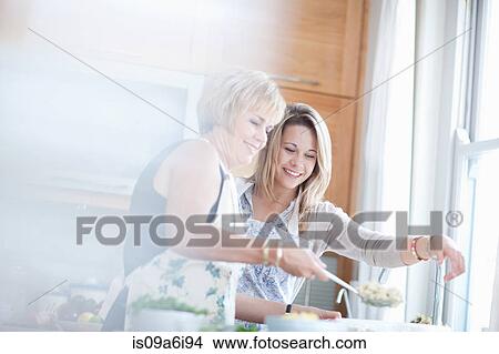 Picture - Mother and daughter cooking in kitchen. Fotosearch