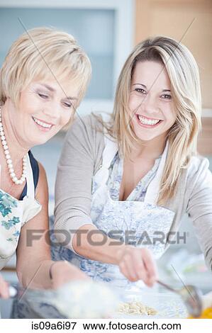 Stock Photo - Mother and daughter cooking in kitchen. Fotosearch