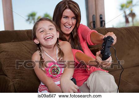 Stock Photo - Mother and daughter playing video games. Fotosearch