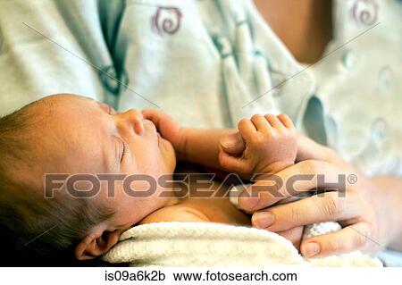 Stock Image - Mother holding newborn infant. Fotosearch
