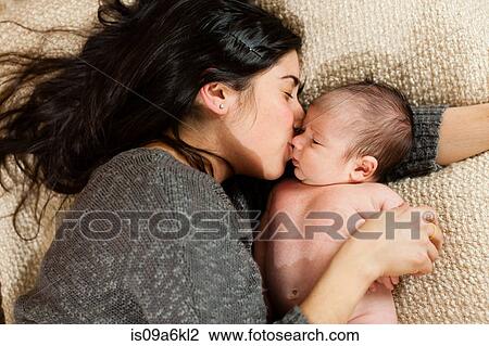 Mother kissing newborn infant on bed View Large Photo Image Stock Image - Mother kissing newborn infant on bed. Fotosearch