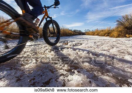 Mountain biker on snow in rural field View Large Photo Image Stock Photo - Mountain biker on snow in rural field. Fotosearch