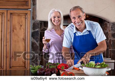 Picture - Older couple cooking in kitchen. Fotosearch