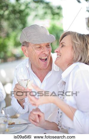 Stock Image - Older couple eating together outdoors. Fotosearch