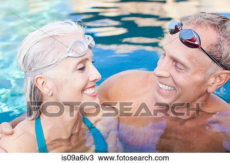 Stock Image - Older couple swimming in pool. Fotosearch