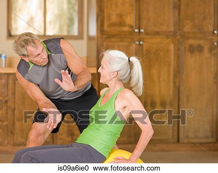 Stock Image - Older couple working out at home. Fotosearch
