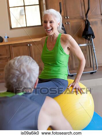 Stock Image - Older couple working out at home. Fotosearch