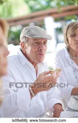 Older friends eating together outdoors View Large Photo Image Stock Image - Older friends eating together outdoors. Fotosearch